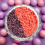 Bowl containing purple and pink sprinkles arranged in a yin-yang pattern.