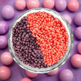 Bowl containing purple and pink sprinkles arranged in a yin-yang pattern.