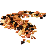 Assorted mix of nuts, dried fruits, and seeds scattered on a white surface.