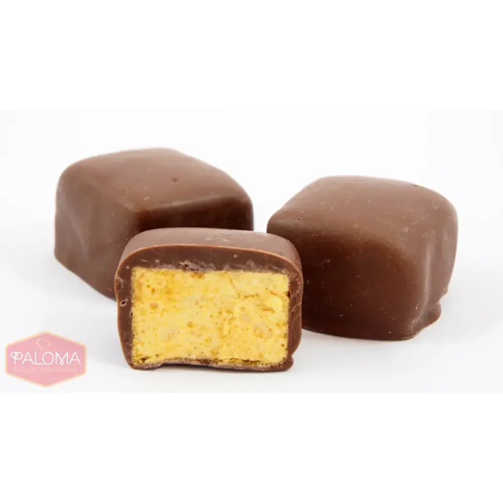 Chocolate-covered candies with a yellow filling, one cut in half to show the interior.