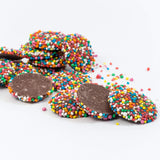 Chocolate discs covered in colorful candy sprinkles.