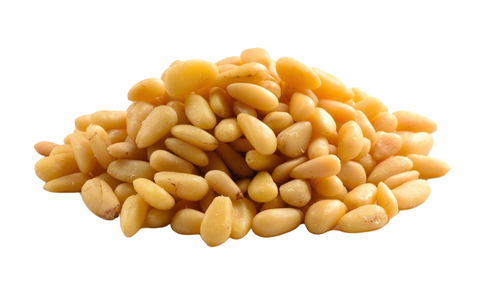 Pile of pine nuts with their characteristic oblong shape and pale yellow color.